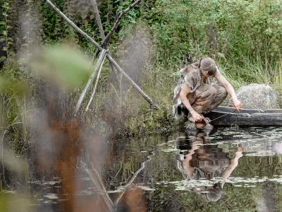 Participating in an archaeology experiment, a contemporary woman dons fur clothing similar to what Paleolithic people in colder climates might have worn.