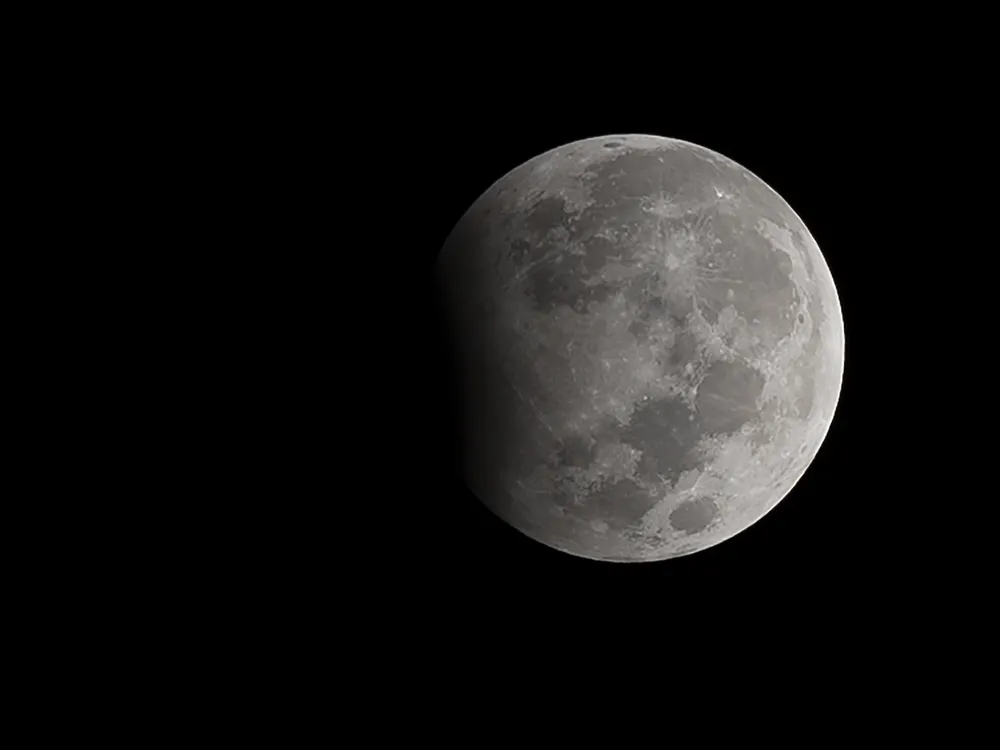 Moon against a black background with a shadow on its left side