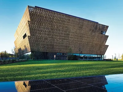 Wrapped in an ornamental bronze latticework, the angular lines of the Museum rise in stark contrast to the rich green landscape.