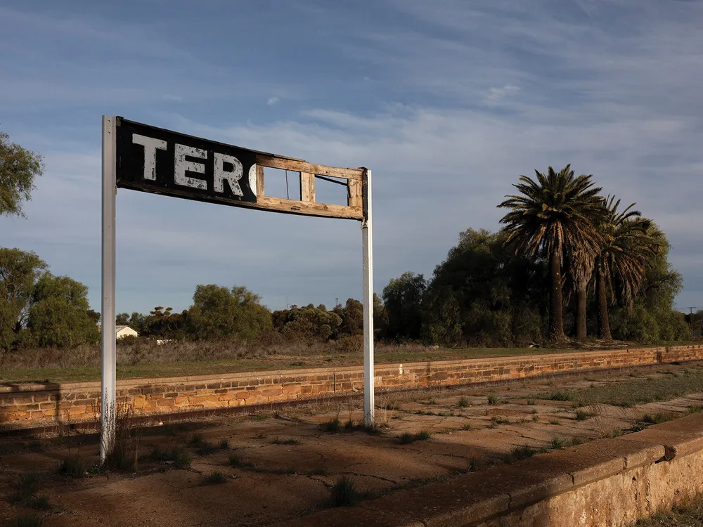 A tattered sign on an abandoned railway stop