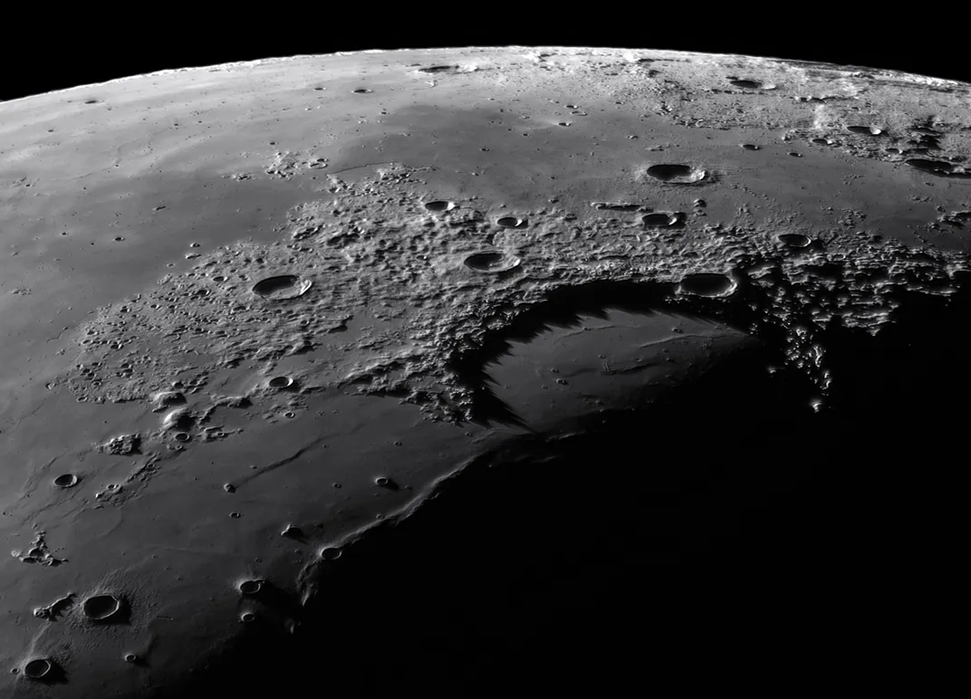 A shot of the moon highlighting the textured craters, mountains, and dry bays