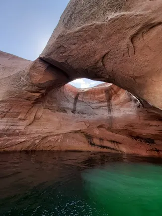 A circular archway rock formation over green water