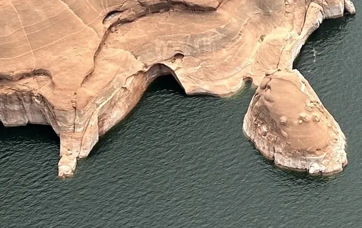 Aerial shot of sandstone rock on the edge of a body of water